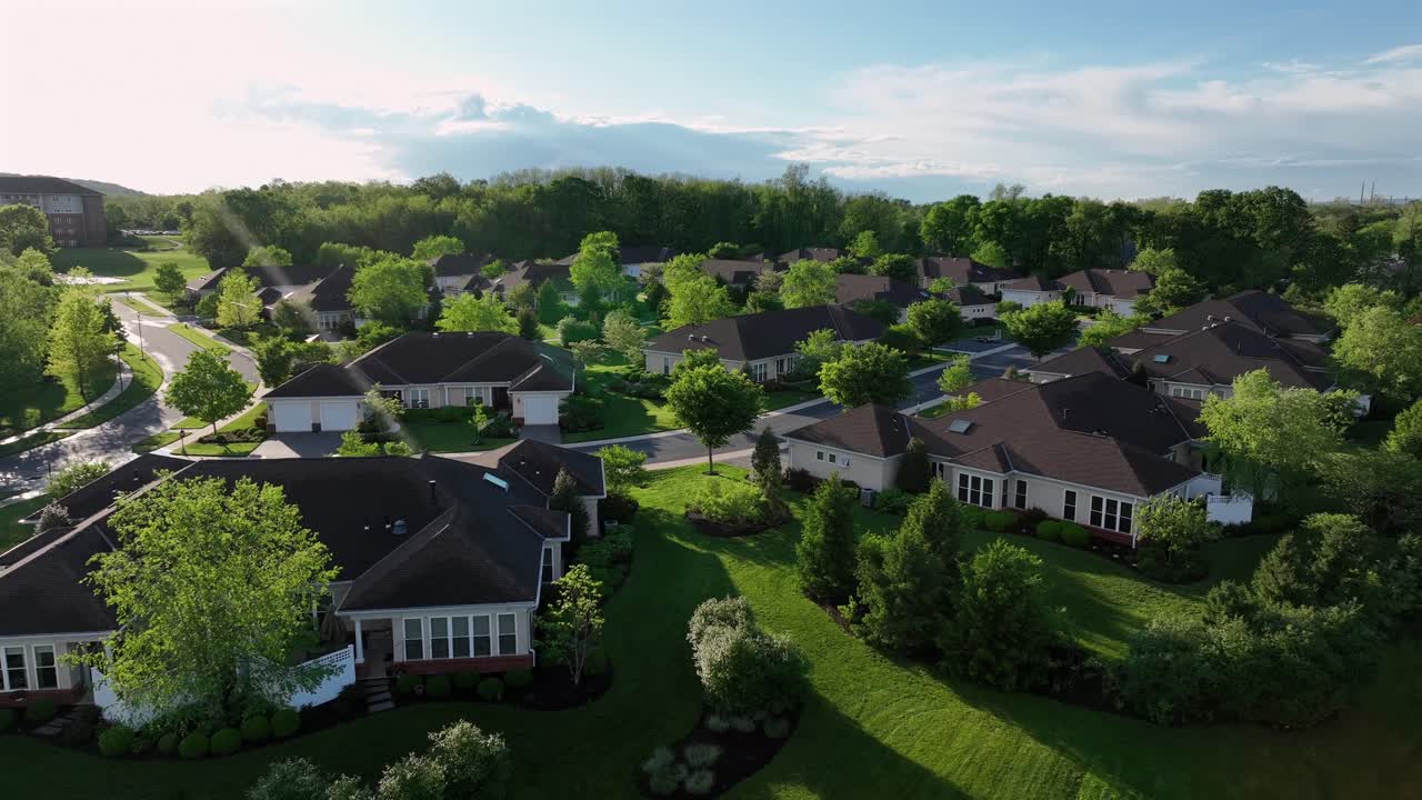 Luxury apartment houses with well-kept garden in american suburb town. Sunny day in spring season. Aerial approaching shot. Retirement homes for rich elderly people in United States.