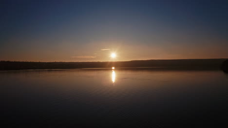 river at sunset. setting sun reflects on the water surface in the evening. beautiful view of the lake with setting sun on the evening sky.