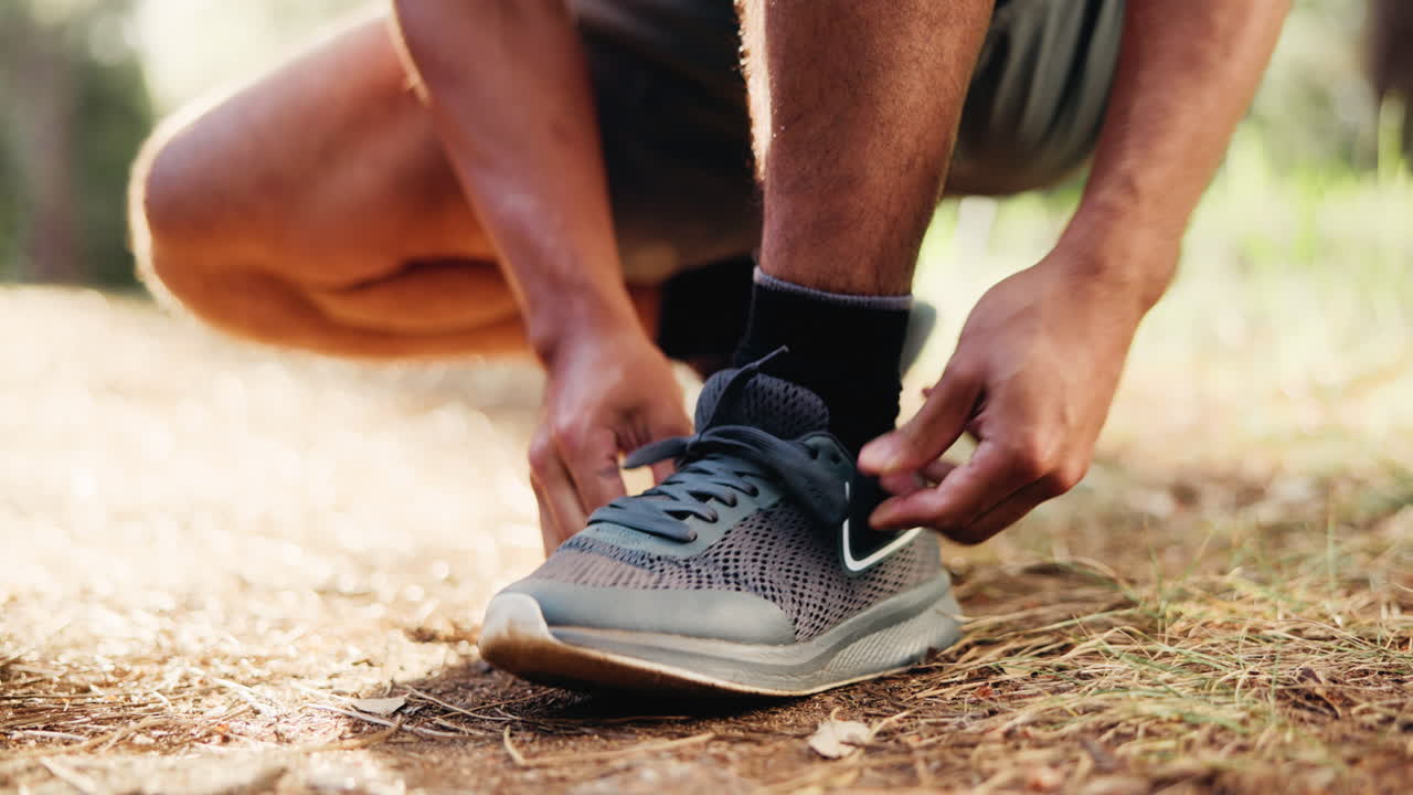 Primo piano di una persona che allaccia i lacci delle scarpe da corsa all'aperto.
