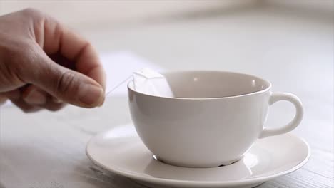 Hand-Mit-Einer-Tasse-Tee-Auf-Einem-Tisch-Sitzend-Stock-Footage-Stock-Foto