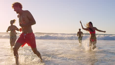 amigos corriendo en las olas del océano