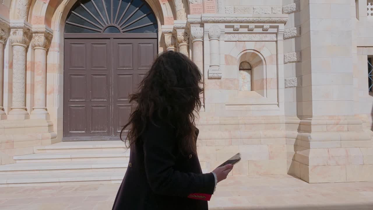 Woman tourist entering the Dormition Abbey in the Old City of Jerusalem. Slow motion.