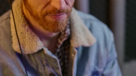 close up on radio or podcast host adjusting microphone and speaks in sound studio. young man's hands set mic close to his mouth. recoding in professional audio room a live streaming podcast show
