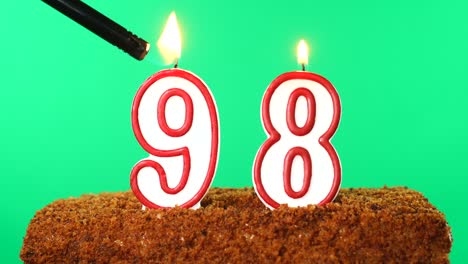 cake with the number 98 lighted candle. chroma key. green screen. isolated