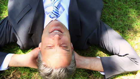 happy businessman lying on the grass