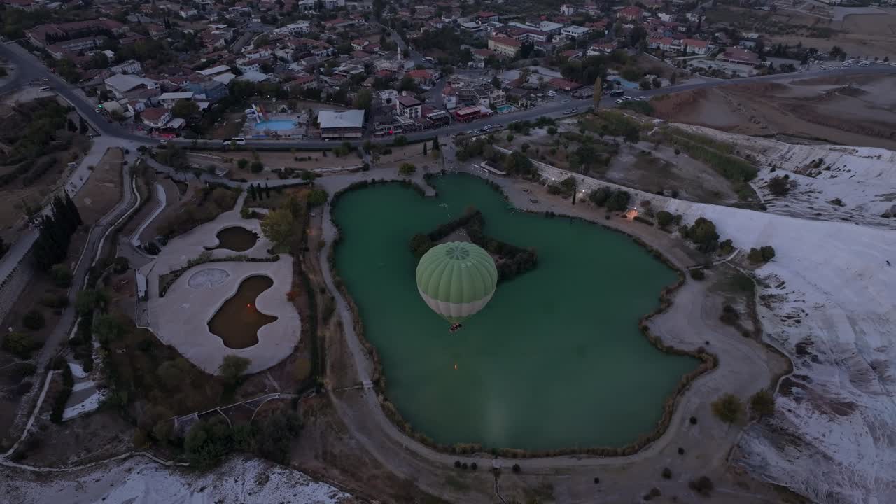 Pamukkale travertenleri ve sıcak hava balonlarının şafak panoraması.