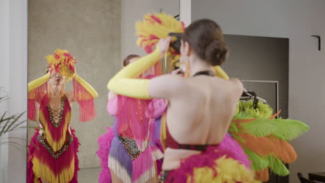 showgirls putting feather headbands on