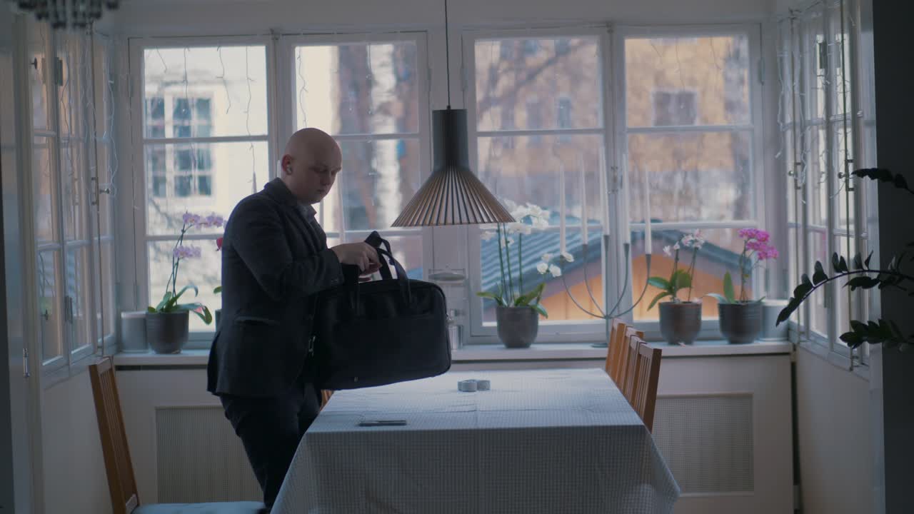 man packing up work and leaving when working from home