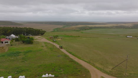 Tracking-of-agricultural-tractor-driving-on-a-dirt-road-in-countryside.-Heading-to-small-family-farm.-South-Africa