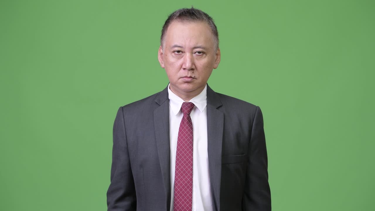 성숙한 일본인 사업가들이 엄지손가락을 내려놓는다.