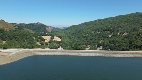 a slow aerial push in of the dam in the uvas reservoir