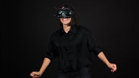 mujer joven feliz con gafas vr en la cabeza bailando en realidad virtual, fondo negro 50fps