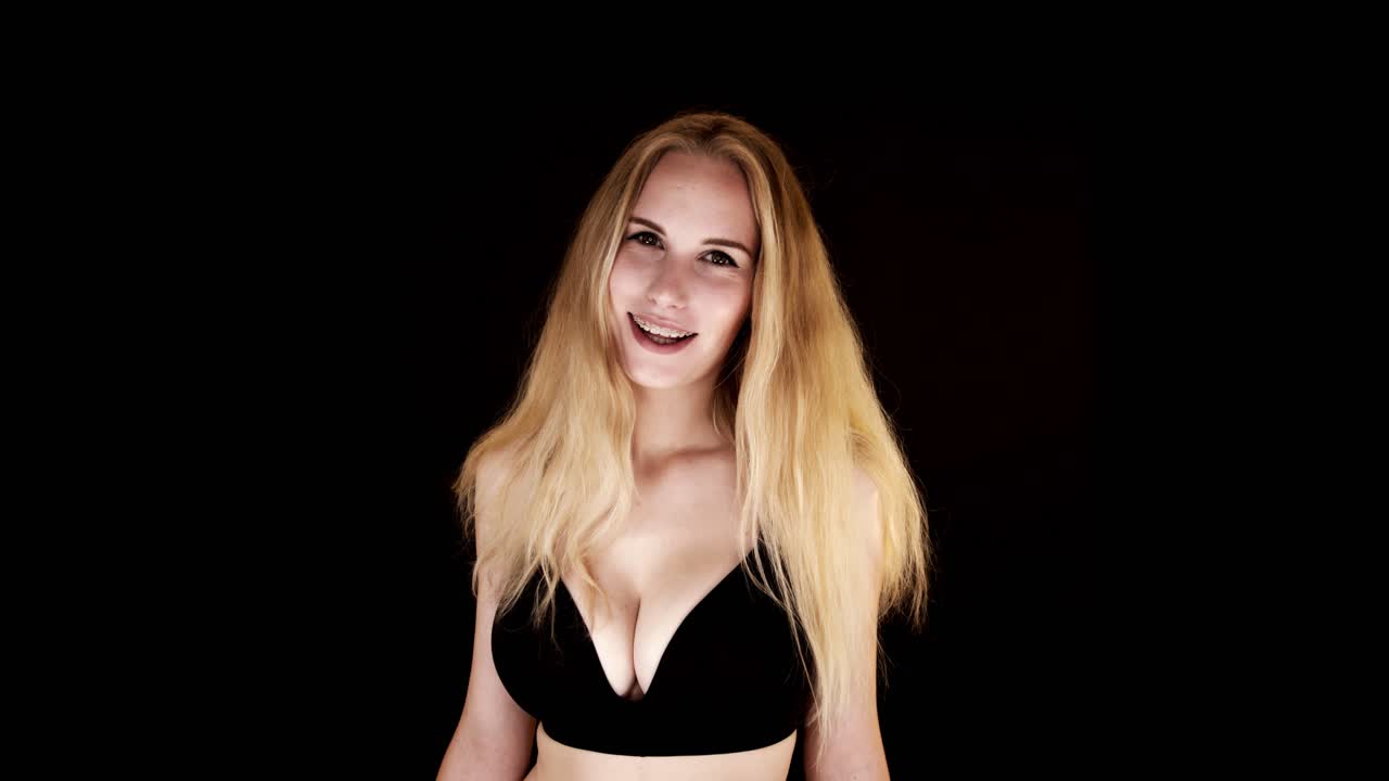 Beautiful Young Woman With Big Natural Breasts In A Black Bra On A Black Background Laughing At The Camera Free Stock Video Footage Download Clips 