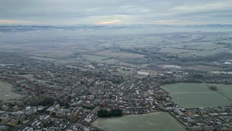 4K-Cinematic-aerial-footage,-depicting-a-rural,-harsh-English-winter-cold-spell-with-mist-and-freezing-temperatures