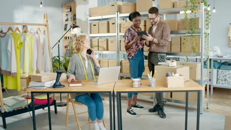 caucasian woman manager taking orders and talking on smartphone in fashion clothing shop