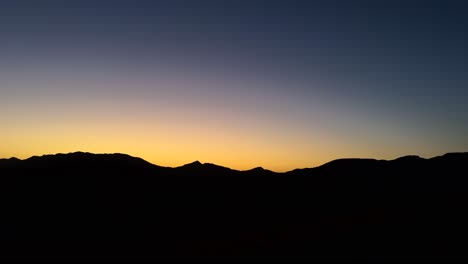 Dunkle-Bergsilhouettenlandschaft-Mit-Farbenfrohem-Sonnenuntergangshimmel-In-Der-Wüste