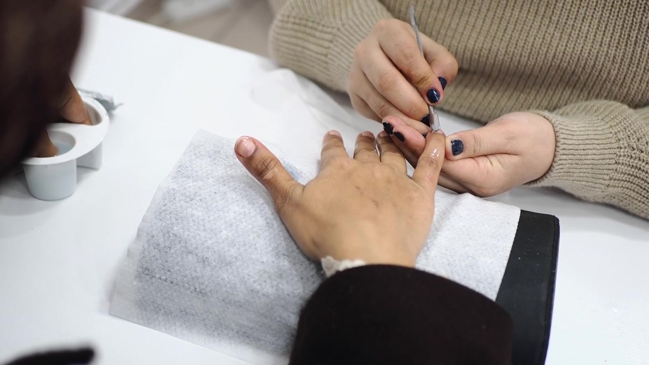 Professional Manicurist Cleaning Cuticles of Client in Beauty Salon