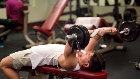 closeup of young bodybuilder doing lying triceps press exercises