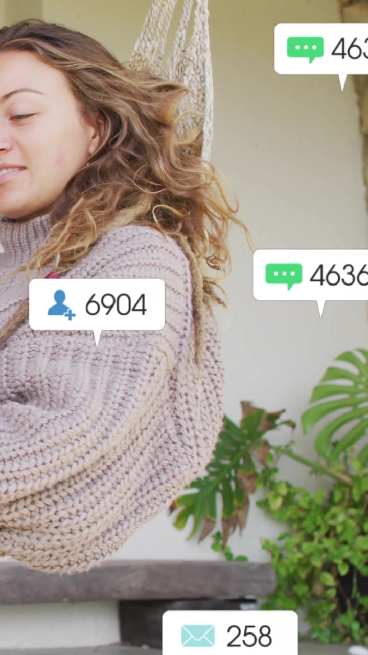 Video verticale: Donna seduta su un'amaca, con avvisi che compaiono e contatori social che aumentano e poi svaniscono