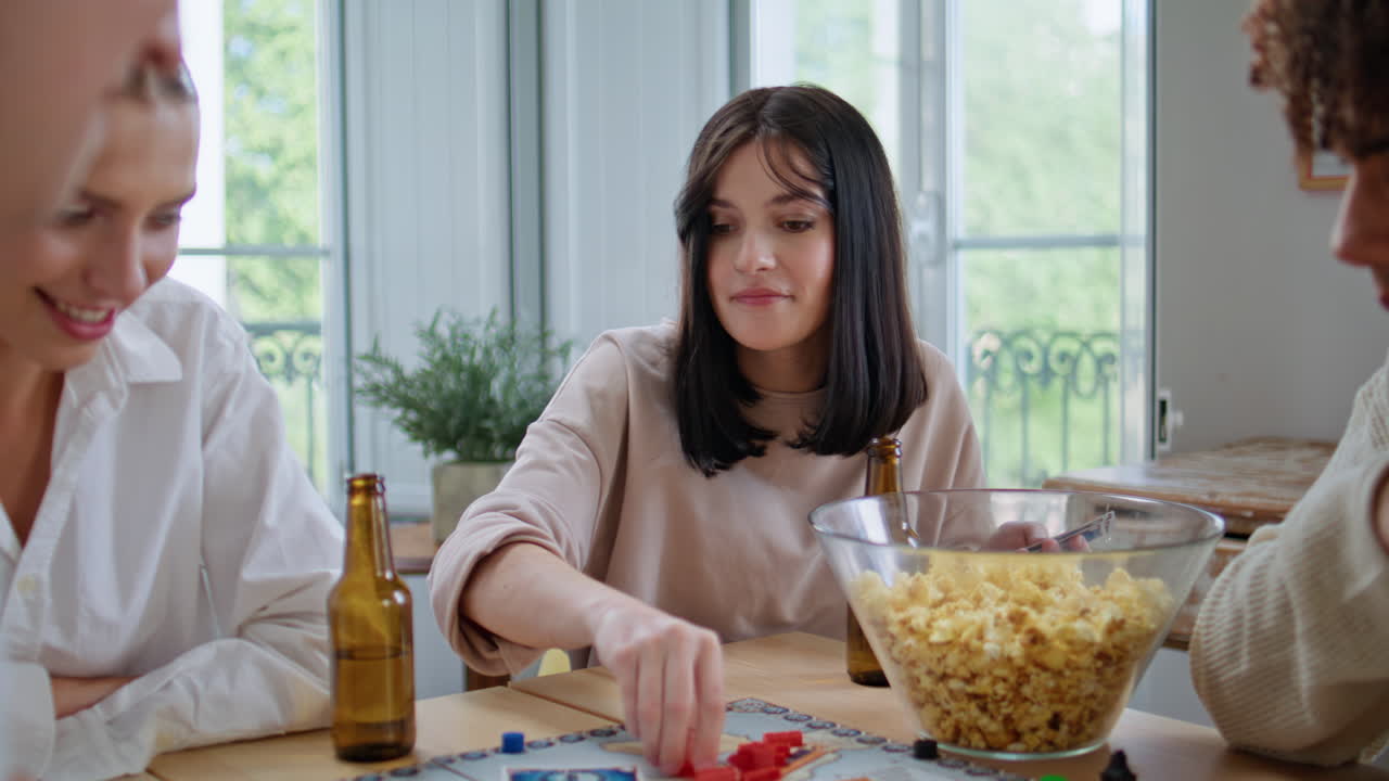 Diverse buddies playing board game together table closeup. Woman shuffling cards