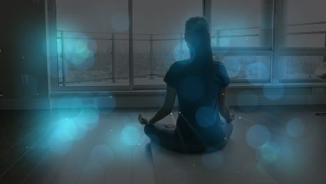 animation of light spots over caucasian woman practicing yoga and meditating