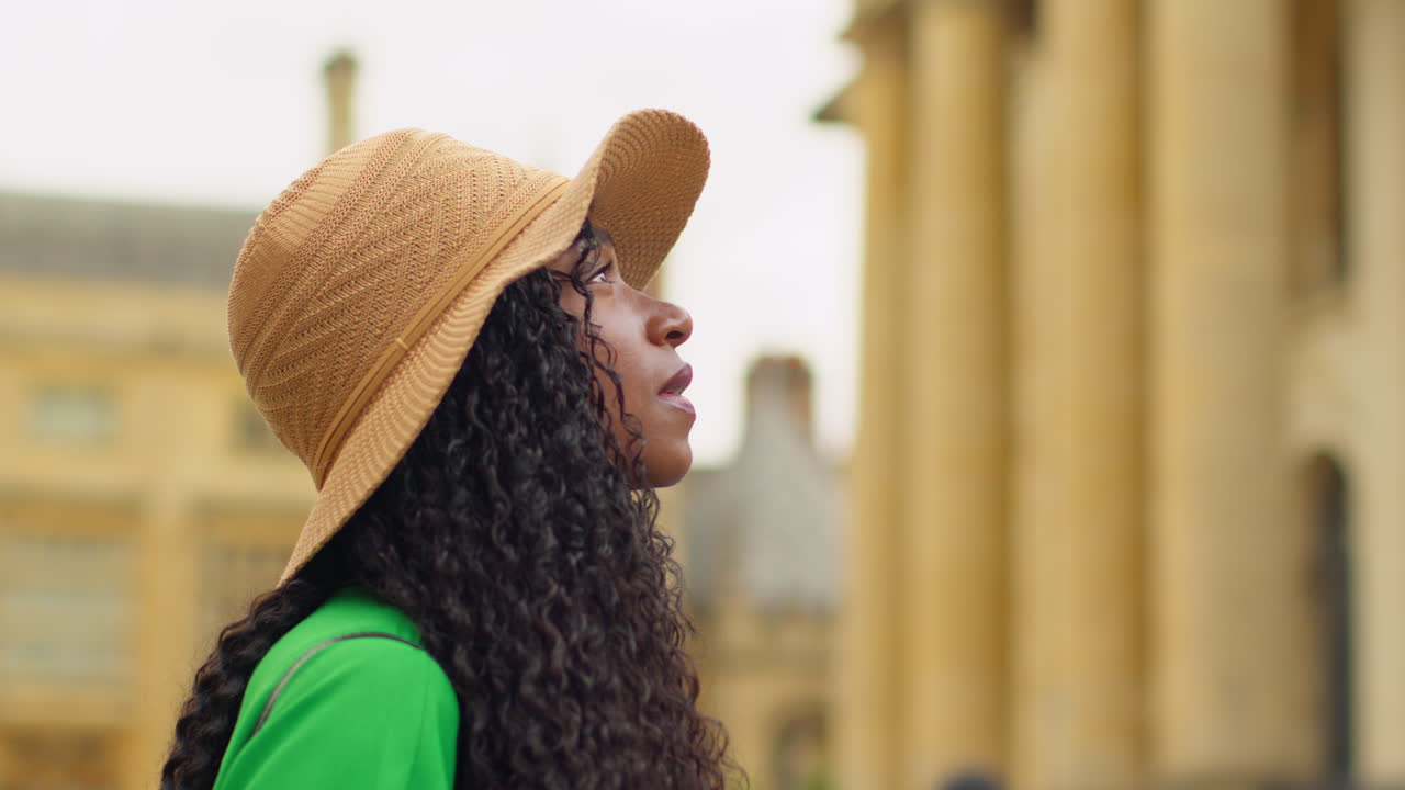 turista femenina con sombrero de paja con cámara de sol de vacaciones en oxford r uk explorando la ciudad caminando por broad street tomando fotos del teatro sheldonian
