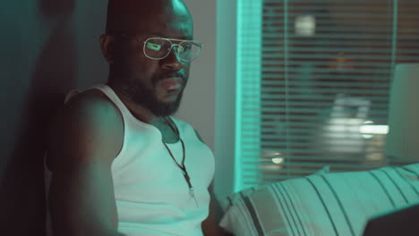 hombre afroamericano usando una computadora portátil por la noche
