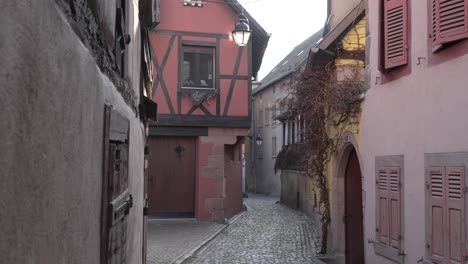 scenic small cobblestone streets in medieval french village kaysersberg with half-timbered architectural buildings