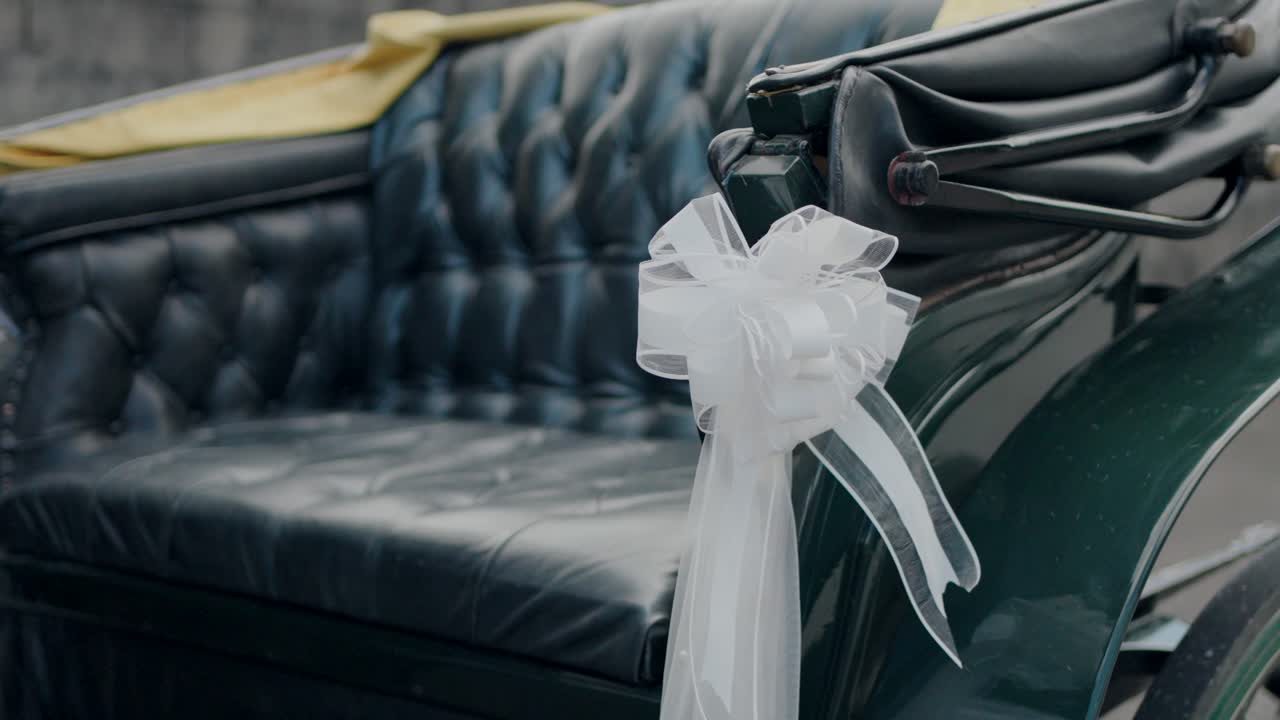 Elegante carruaje de caballos verde para bodas con lazo blanco