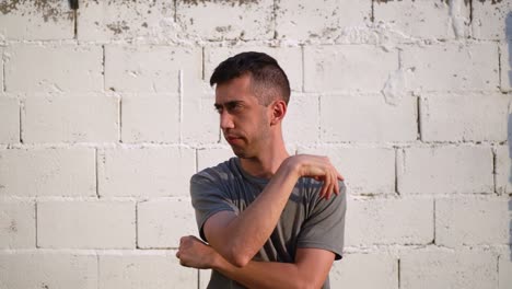 gestures of a young expressive man pondering thoughts outdoor against white wall background