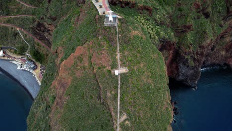Aerial-view-pulling-back-across-Ponta-du-Garajau-green-island-coastline,-Madeira,-Portugal