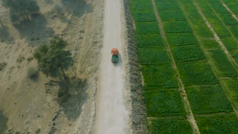 Rear-aerial-view-of-4X4-Jeep-driving-in-rural-roads-of-Sindh,-Pakistan