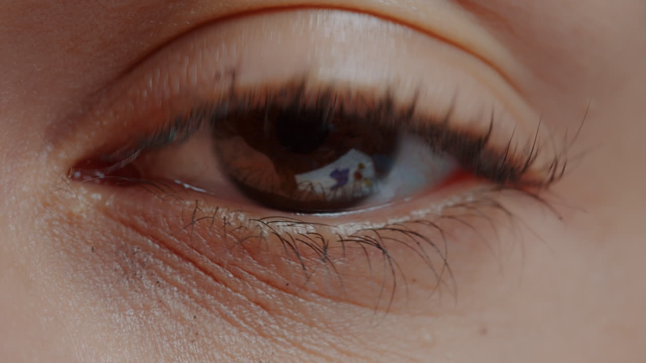 Brown eye with mascara on eyelashes blinking in front of camera