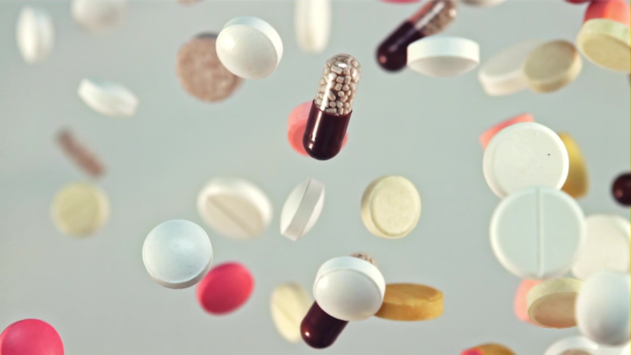 Colorful Pills and Capsules Falling in Slow Motion