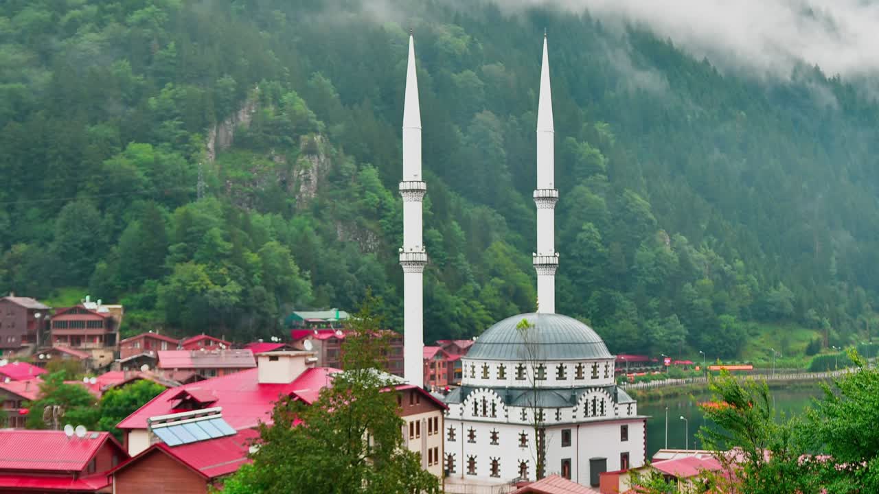 Uzungöl göl kıyısında, sisli yeşil dağ doğasıyla sabahleyin güzel beyaz cami dış mimarisi