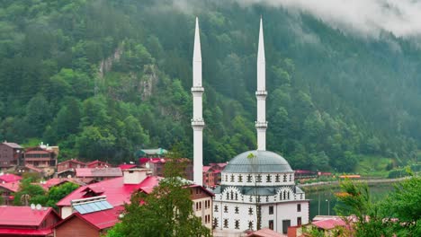 beautiful white mosque exterior architecture at uzungol lake coast in the morning with misty green mountains nature