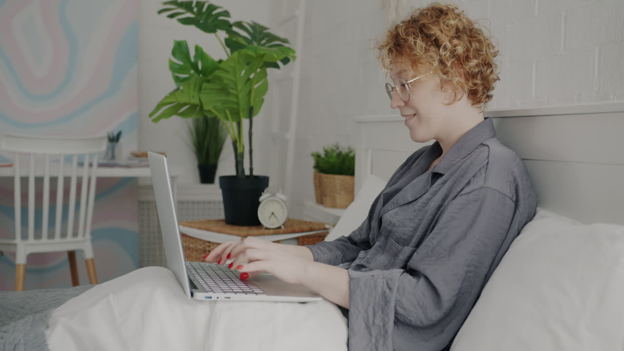 mujer trabajando en la computadora portátil en la cama