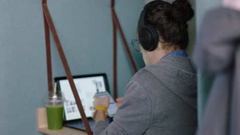 Joven-Estudiante-Caucásico-Usando-Una-Computadora-Portátil-Digital-Trabajando-En-Una-Lluvia-De-Ideas-De-Negocios-Explorando-Estudios-En-Línea-En-Un-Cubículo-De-Oficina-Privado-Escuchando-Música-Usando-Auriculares