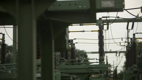 Close-up-of-industrial-high-voltage-power-lines-at-a-substation-with-focus-on-insulators-and-cables