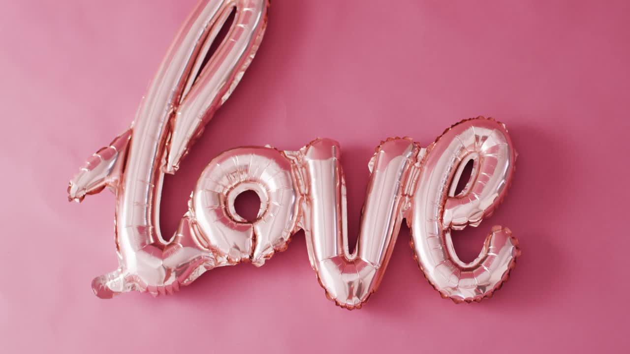 복사 공간과 함께 분홍색 배경에 반 ⁇ 이는 희미한 분홍색 사랑 텍스트 풍선의 오버헤드 비디오