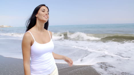 Mujer-Caminando-Por-La-Playa-Y-Sonriendo-A-La-Cámara