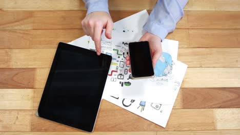 Woman-using-mobile-phone-and-digital-tablet-while-working-at-desk