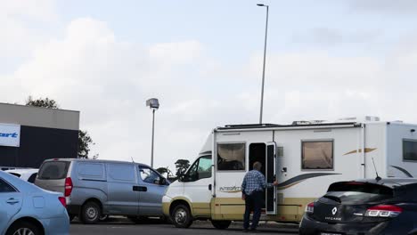 individual approaches and enters a parked motorhome