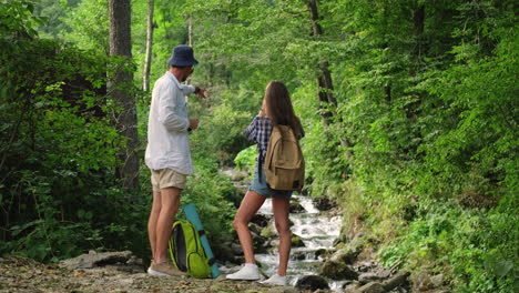 couple hiking in a forest by a stream