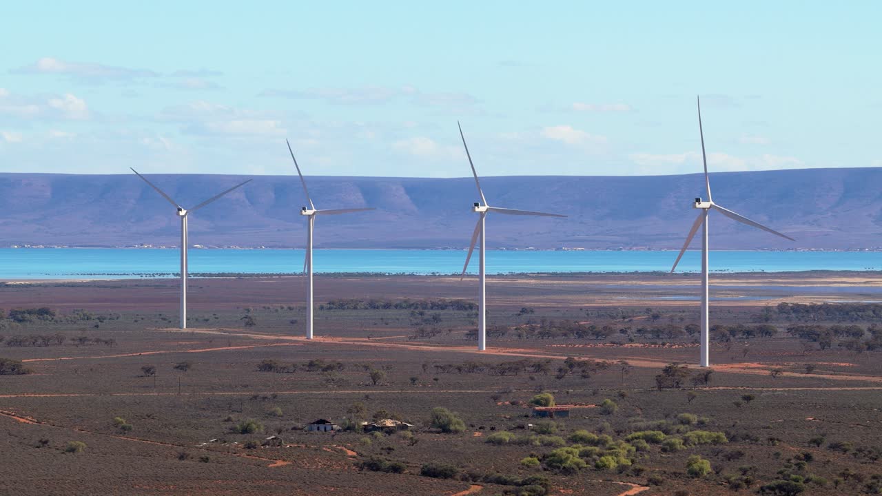 Telephoto drone view of wind turbines with ocean and ridge backdrop, Port Augusta, South Australia