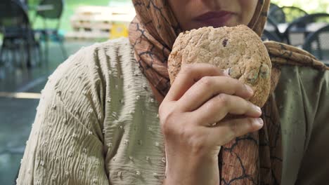 woman eating a chocolate chip cookie