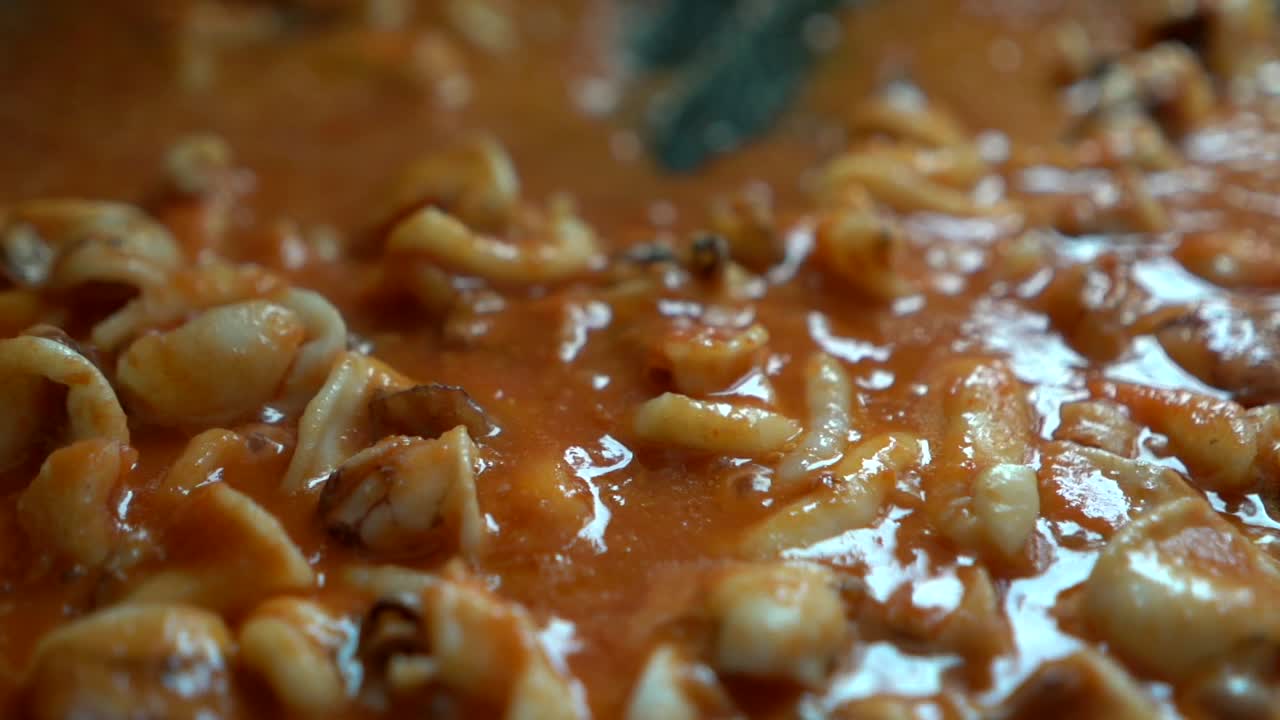 preparing tomato sauce with squid during the preparation of Mediterranean fideua