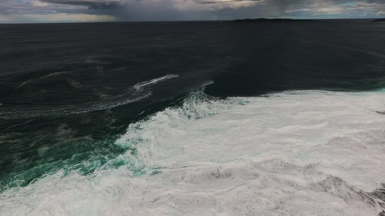 Waves roll toward rocky coastline in rhythmic clean lines at sunrise