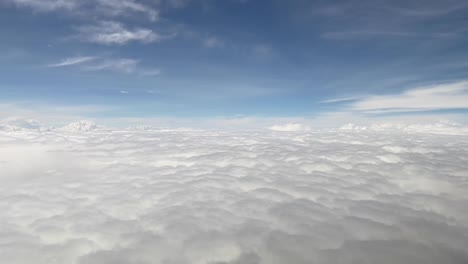 sea of clouds from a cockpit during daylight with cotton clouds and deep blue sky