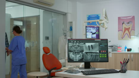 nurse typing on computer with digital x-ray